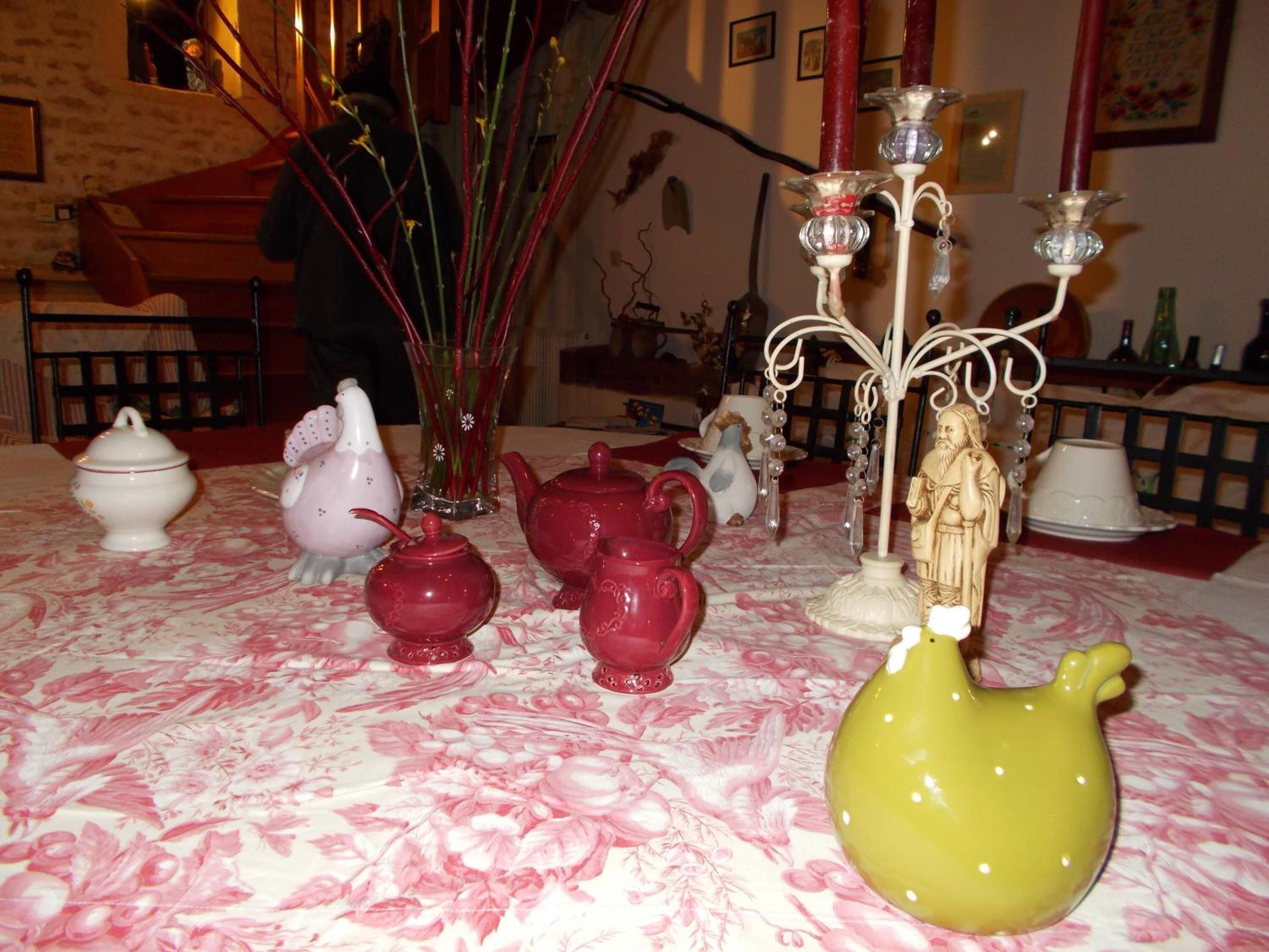 A table with various ceramic teapots and a figurine.