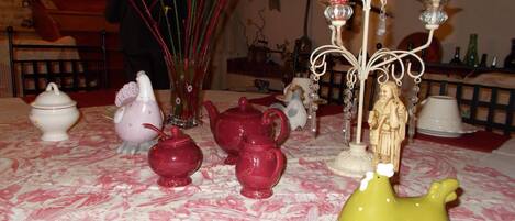 A table with various ceramic teapots and a figurine.