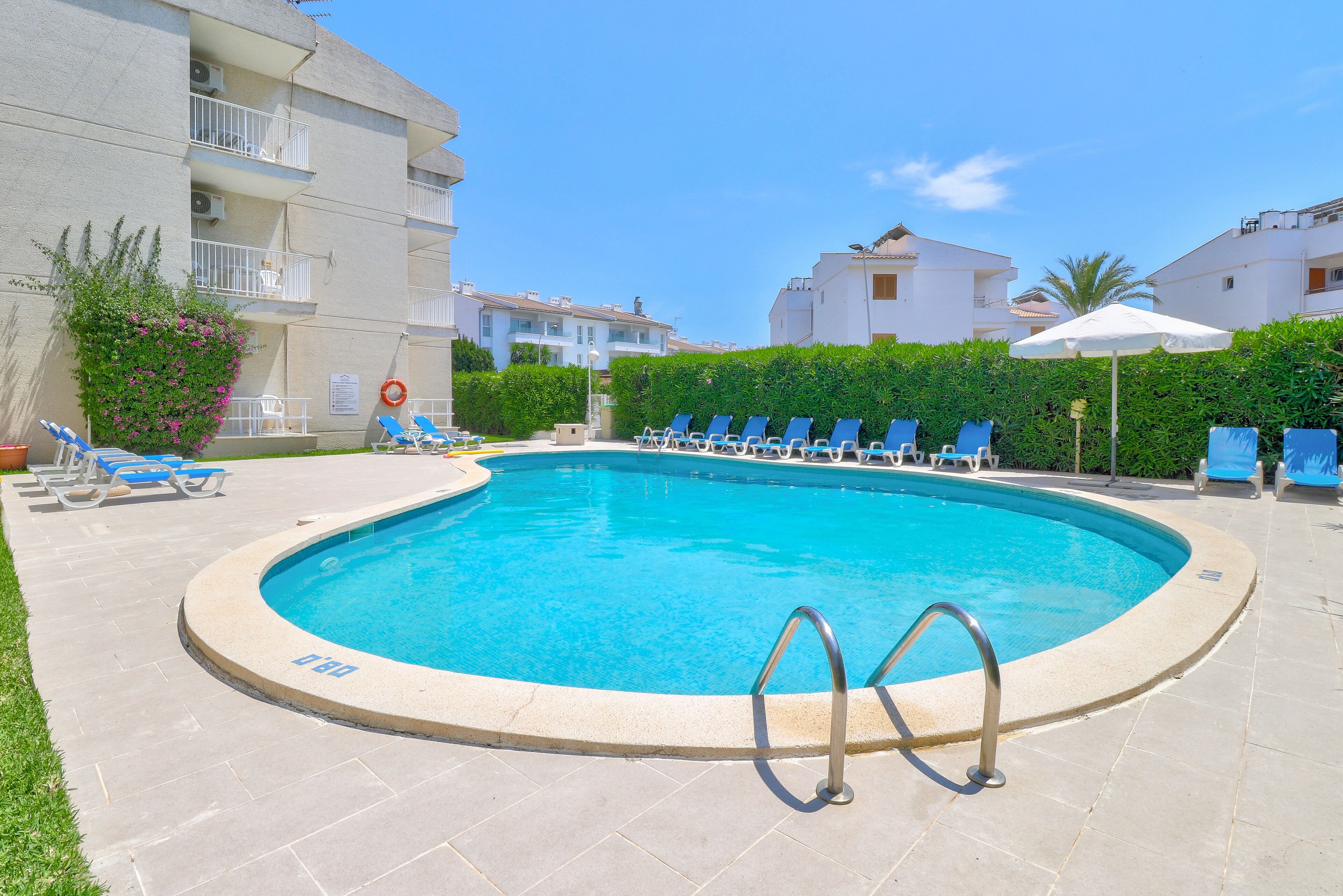 Une piscine équipée de chaises longues et d’un poste de surveillance pour les sauveteurs.