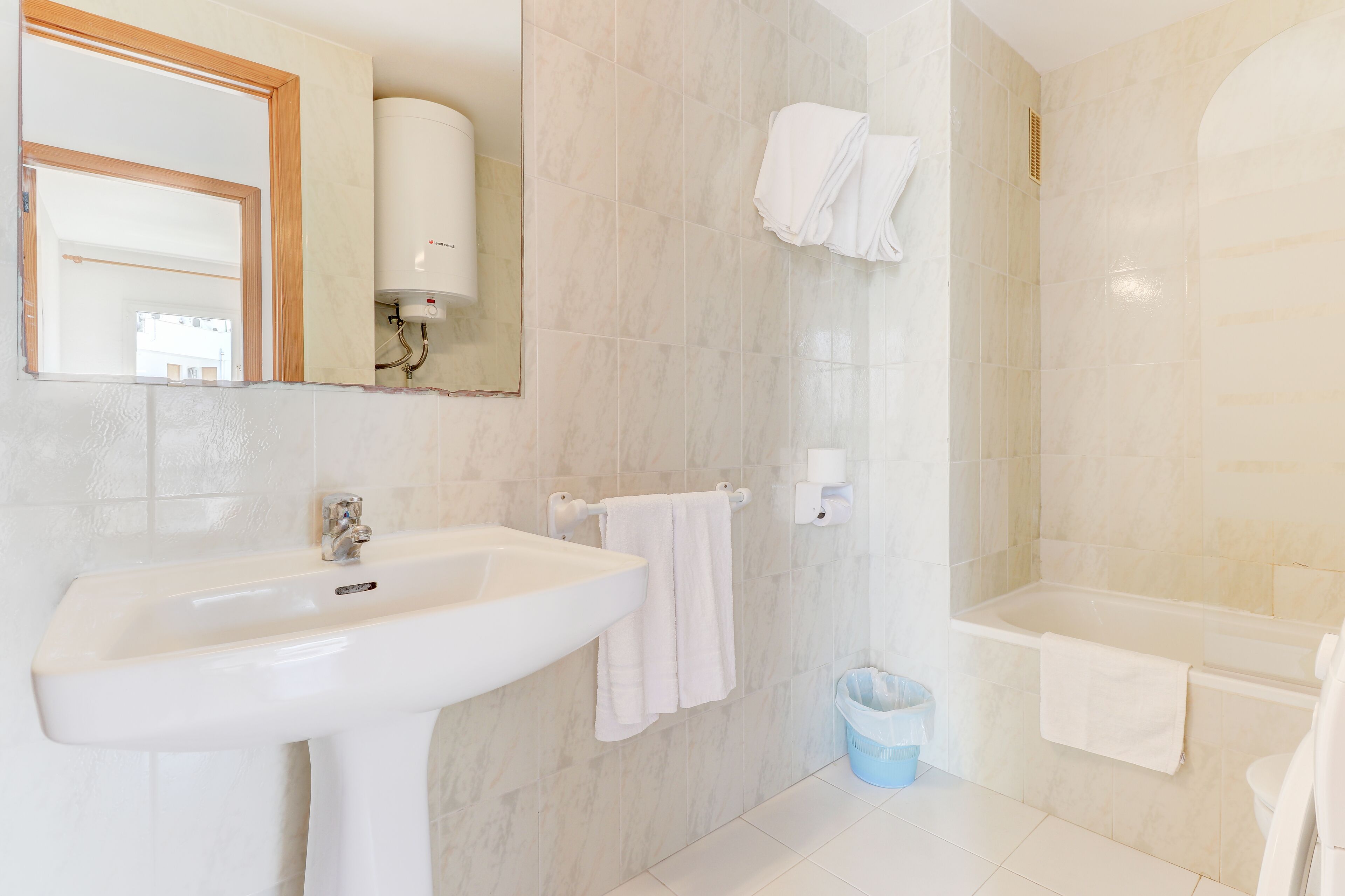 Un bagno con lavandino, specchio, porta asciugamani, doccia e vasca da bagno.