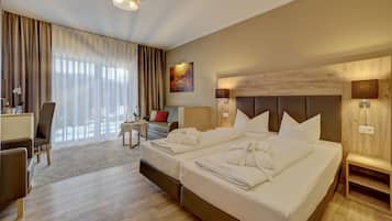 Ein Hotelzimmer mit einem großen Bett, einem Schreibtisch, einem Sessel und einer Couch.