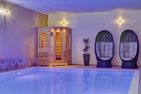 Una piscina techada, sillones reclinables de piscina