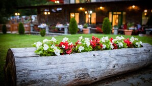 Ein hölzerner Pflanzkasten mit Blumen in einem Garten.