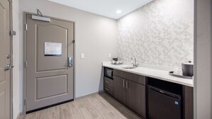 A modern kitchen with a beige door, a microwave, a dishwasher, and a sink. - Hampton Inn & Suites Ruidoso Downs (Ruidoso Downs)