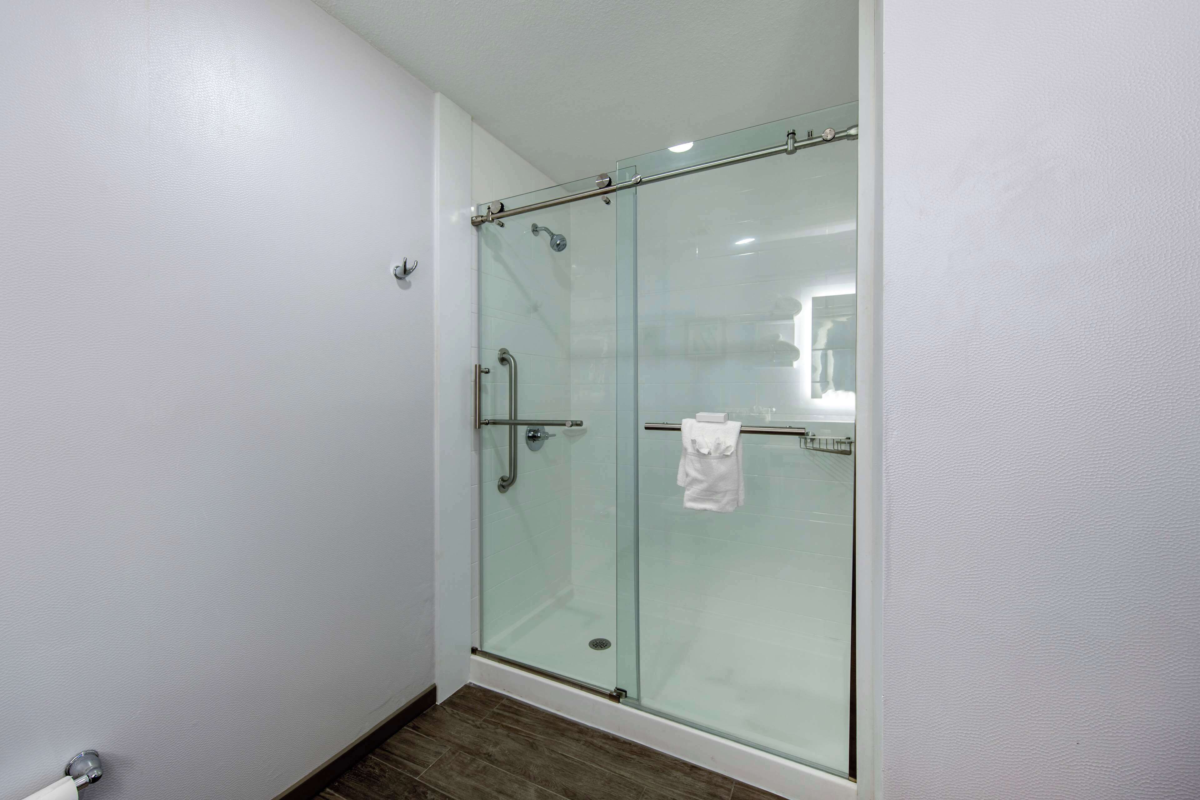 A glass-enclosed shower with a towel rack and a visible towel.