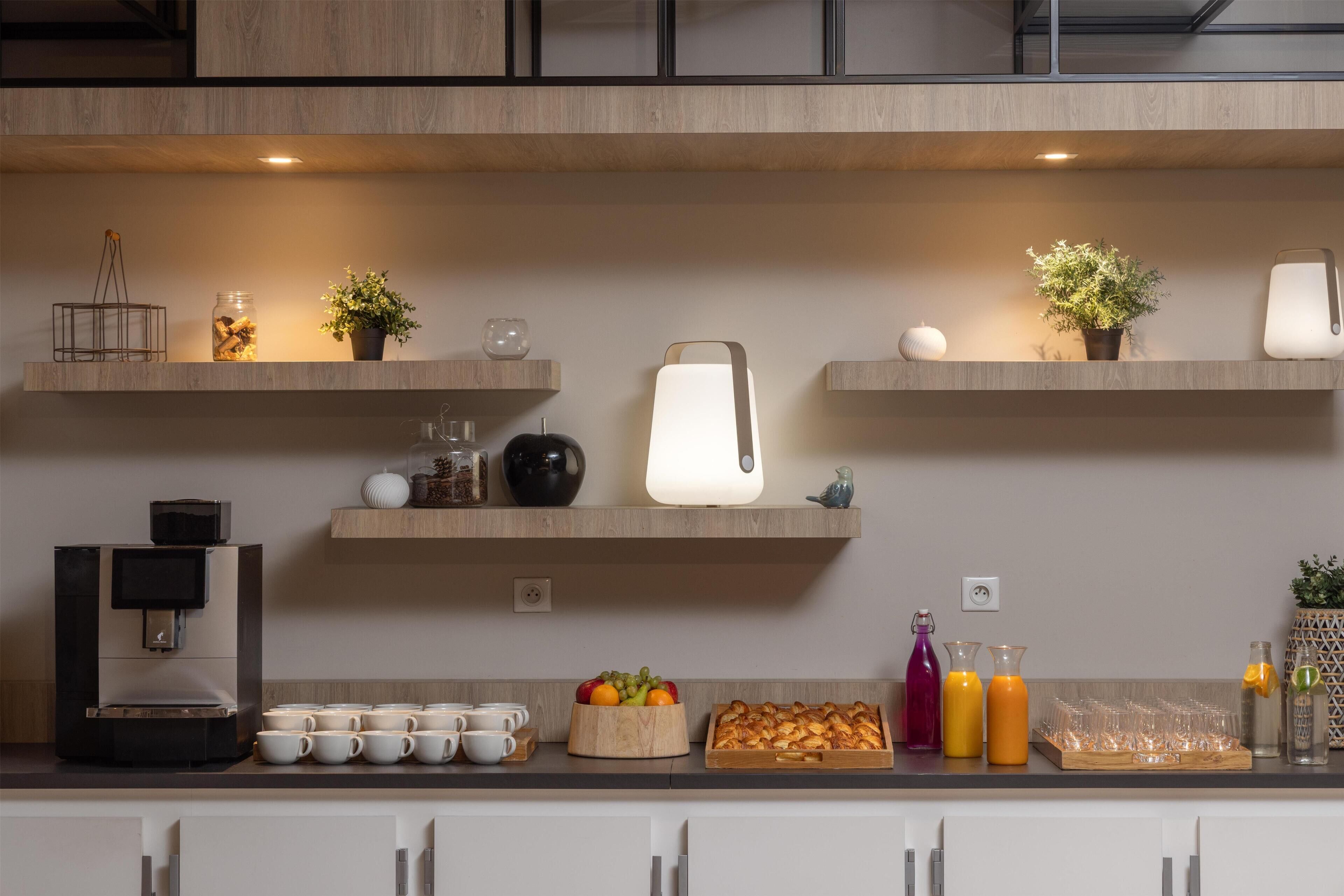 A modern kitchen with wooden shelves, a coffee machine, and various kitchenware.