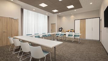 A conference room with a long table, chairs, a projector, and a screen.