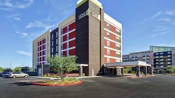 A multi-story hotel with a prominent 'Home2Home' sign, a covered entrance, and a parking lot.