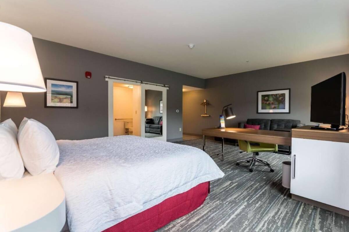Une chambre d’hôtel avec un lit, un bureau et une télévision.
