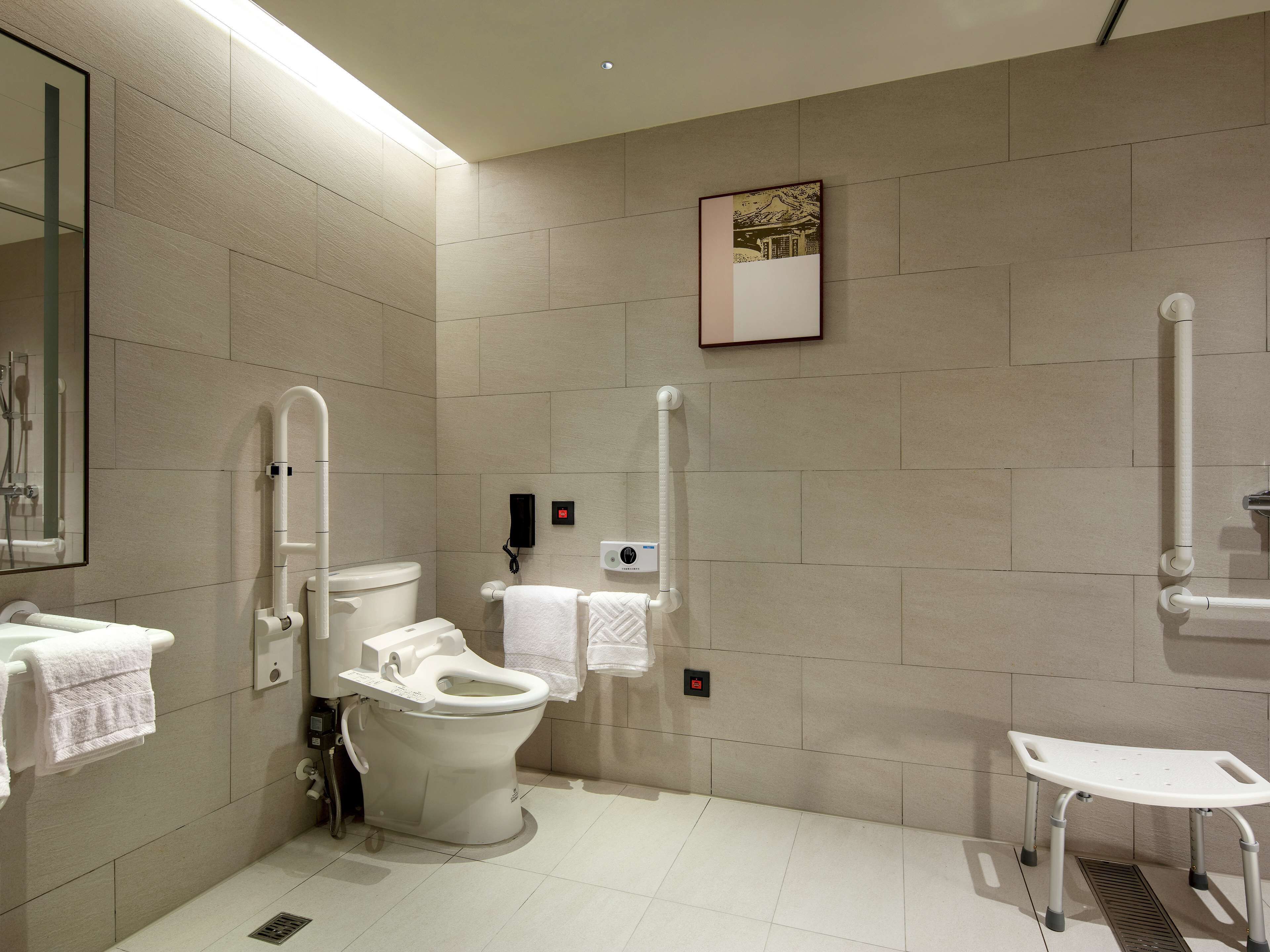Een moderne badkamer met toilet, bidet en douchestoel.