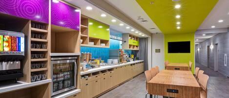 A modern kitchen with a long counter, built-in appliances, and a variety of storage cabinets.