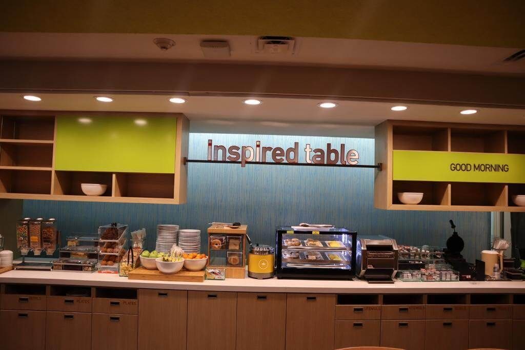 Ein Frühstücksbuffet mit einem Schild mit der Aufschrift "Inspired Table" und einem Schild, das "Guten Morgen" zeigt.