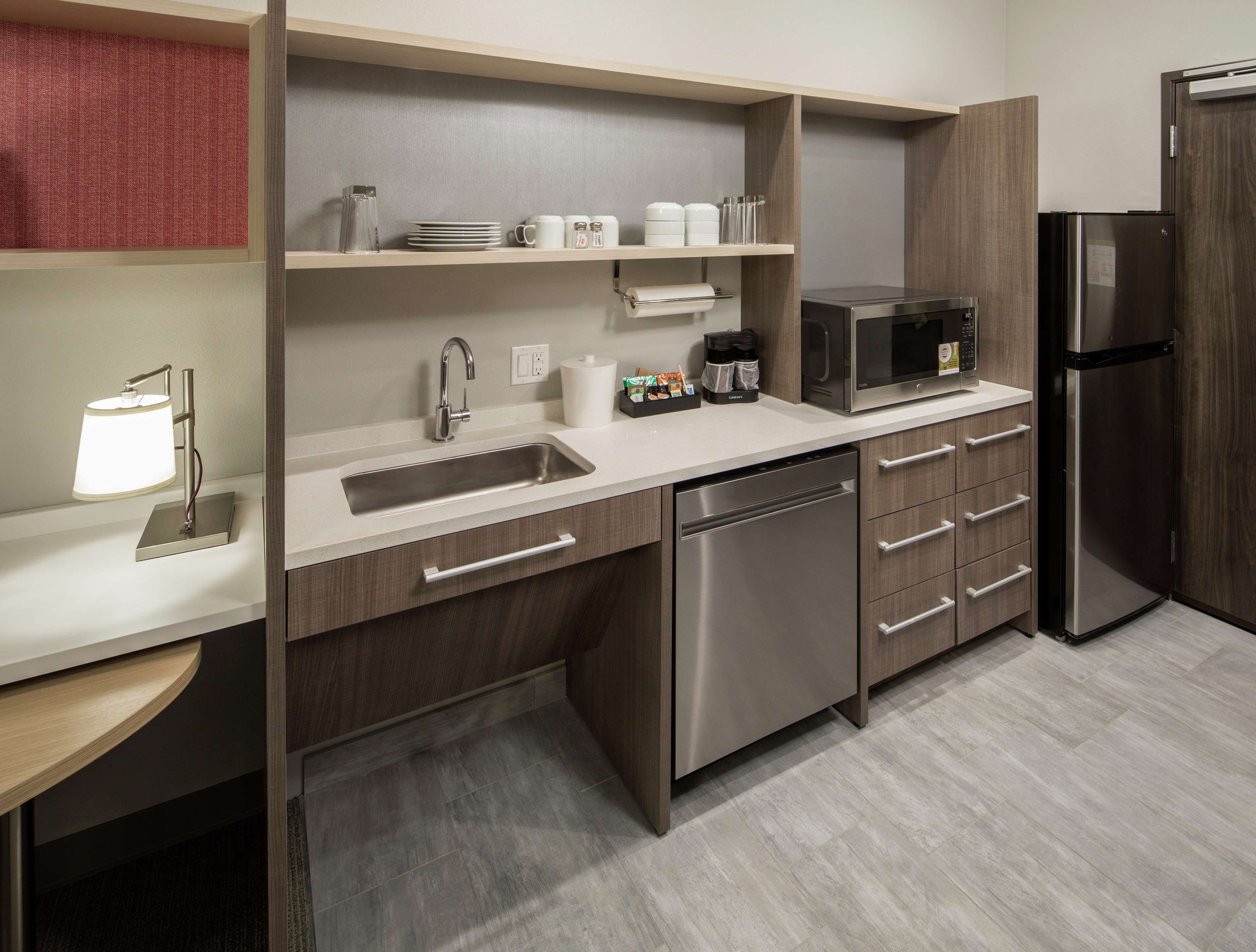 A modern kitchen with a stainless steel dishwasher, a microwave, and a refrigerator.