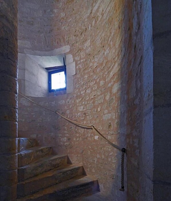 A stone staircase with a small window at the top. - Association Le prieuré Saint Barthélémy (Azay-le-Brule)