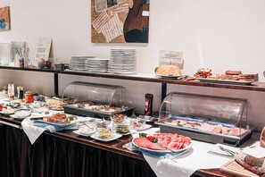 A buffet with various food items, including meats, salads, and desserts, arranged on a table with a white tablecloth. - Hotel International Am Theater (Münster)