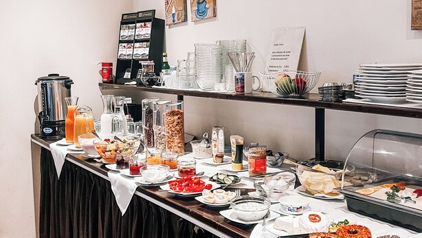 Un buffet proposant une variété de plats, de boissons et d’ustensiles.