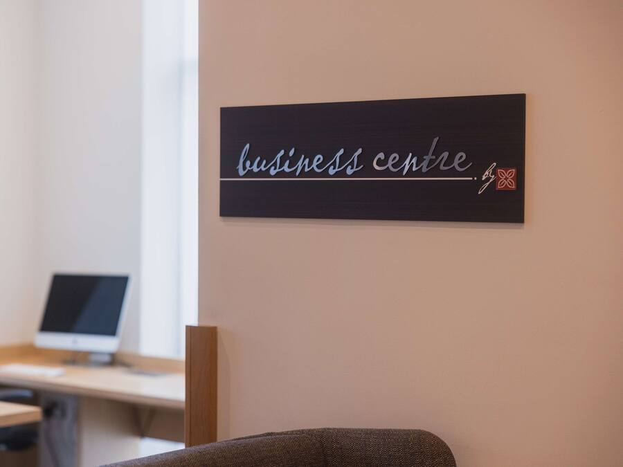 A workspace with a desk, a computer, and a sign that reads "business centre".