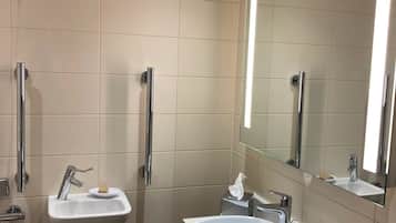 Un baño moderno con dos lavamanos, un espejo grande y un mueble tocador con artículos de aseo.