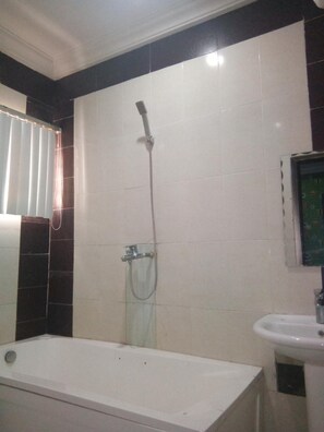A bathroom with a bathtub, a shower, and a sink. - Viclin Diamond Hotels (Abuja)