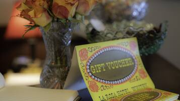 A table with a vase of roses and a gift voucher from La Rosa Hotel.