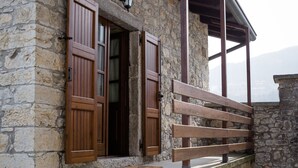 Un edificio de piedra con puertas de madera y una banca en el exterior.