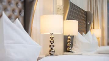 Camera d'albergo moderna con un letto grande, due abat-jour e un ampio specchio che riflette l'arredamento.