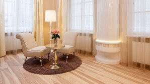 A room with two armchairs, a small round table with a lamp, a vase with flowers, and a radiator. - Hapimag Resort Salzburg (Salzburg)