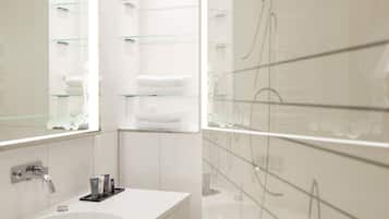 A modern bathroom with two sinks, glass shelves, and a mirror with decorative script.