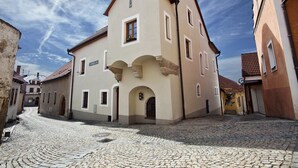 A historic building with a central archway, a sign reading "Hotel", and a cobblestone street. - Staroměstský penzion (Tabor)