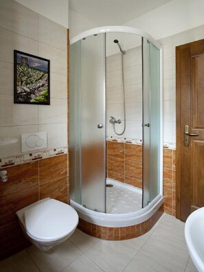 A bathroom with a glass-enclosed shower, a toilet, and a bathtub. - Staroměstský penzion (Tabor)