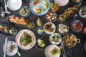Variedad de platos sobre una mesa, incluyendo un sándwich, ensaladas y un tazón de sopa.
