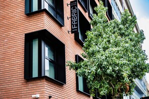 Un hotel con fachada de ladrillo, ventanas con marcos negros y un letrero que indica que es un hotel.