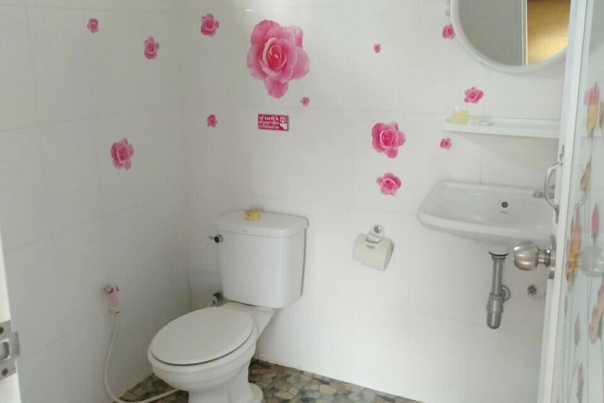 A small bathroom with a toilet, sink, and a mirror.
