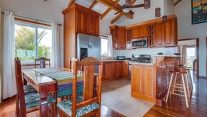 Una cocina amplia con armarios de madera, una isla grande y una zona de comedor con mesa y sillas.