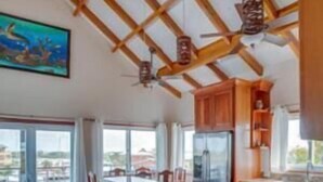 Una cocina amplia con vigas de madera, una encimera larga y taburetes de bar.