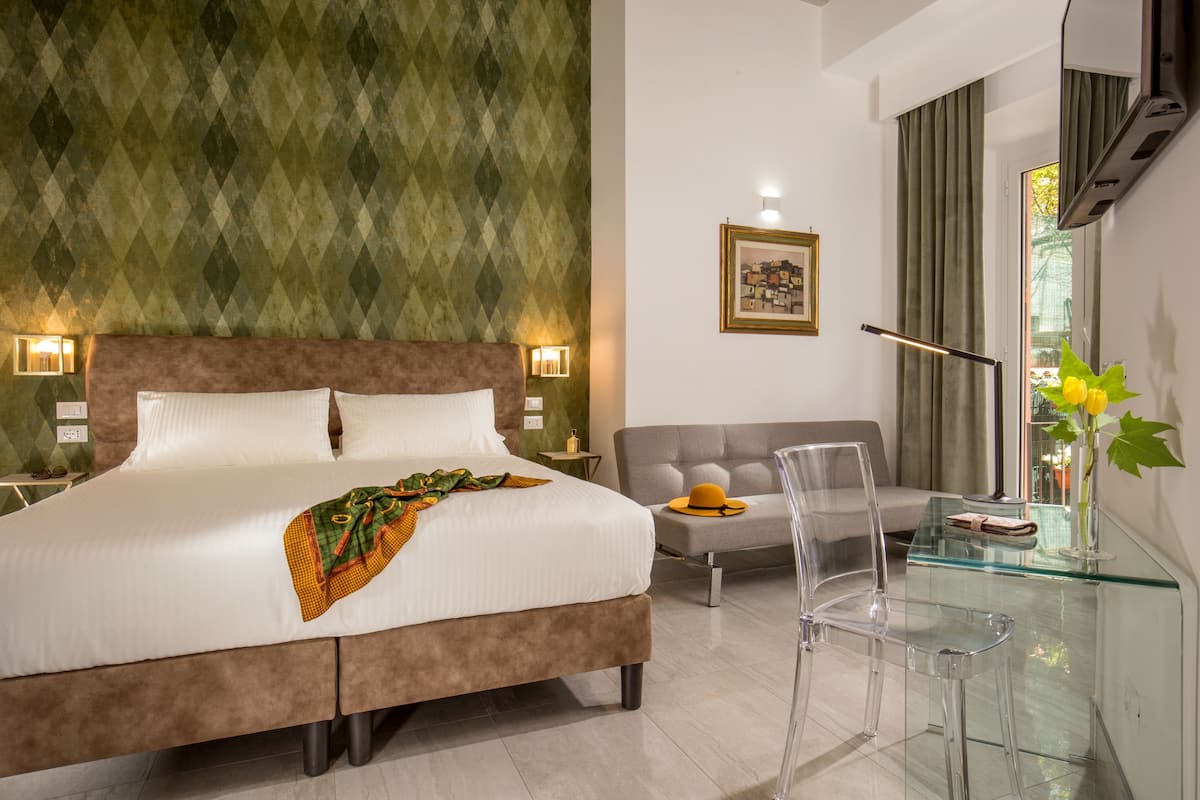 Et moderne hotelværelse med en stor seng, et glasbord, en sofa og en klar stol.