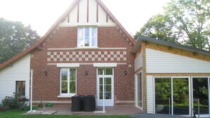 Une maison à deux étages avec une façade en briques, un porche à l’avant et un garage.