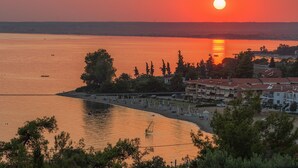 A coastal view with a sunset, a beach, and buildings in the foreground. - Sunday Summer Resort (Polygyros)