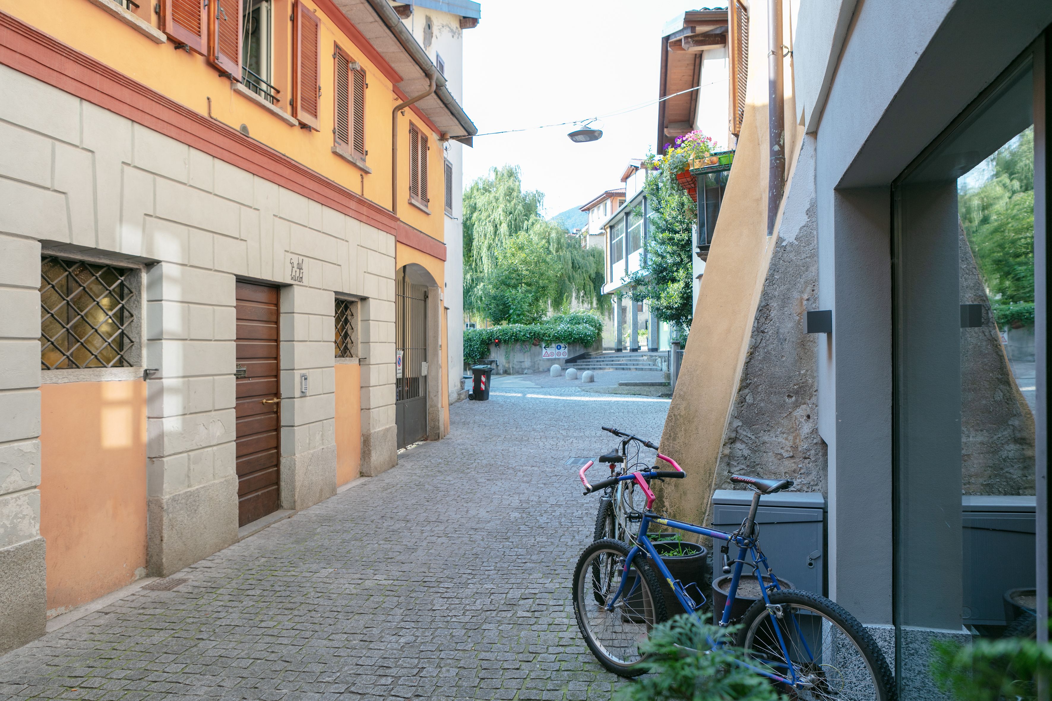 Eine Kopfsteinpflasterstraße mit einem Fahrrad, das an einem Gebäude abgestellt ist.