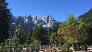 A mountain view with a clear sky, a wooden bench, and a street lamp.
