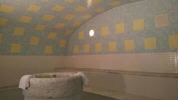 Un bagno piastrellato con vasca, cabina doccia e una piccola finestra.
