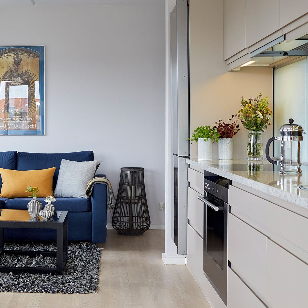 Een moderne woonkamer met een bank, salontafel en een schilderij aan de muur.