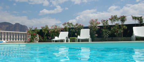 Piscine extérieure, parasols de plage, chaises longues