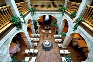 A courtyard with stone arches, white chairs, and a central fountain. - Hotel Convento San Roque (Balmaseda)