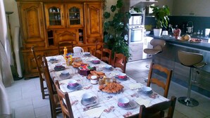 Un comedor con una mesa dispuesta para una comida, rodeado de armarios y sillas de madera.