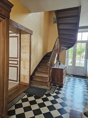 Un escalier avec des marches en bois et une main courante sombre menant à un palier.