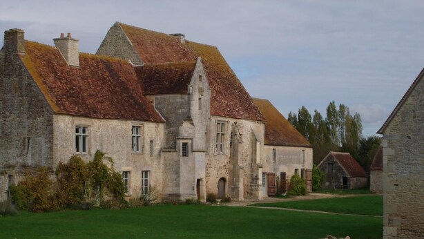 A historic stone building with multiple chimneys and a well-maintained lawn. - Le Manoir de la Baronnie (Boischampré)