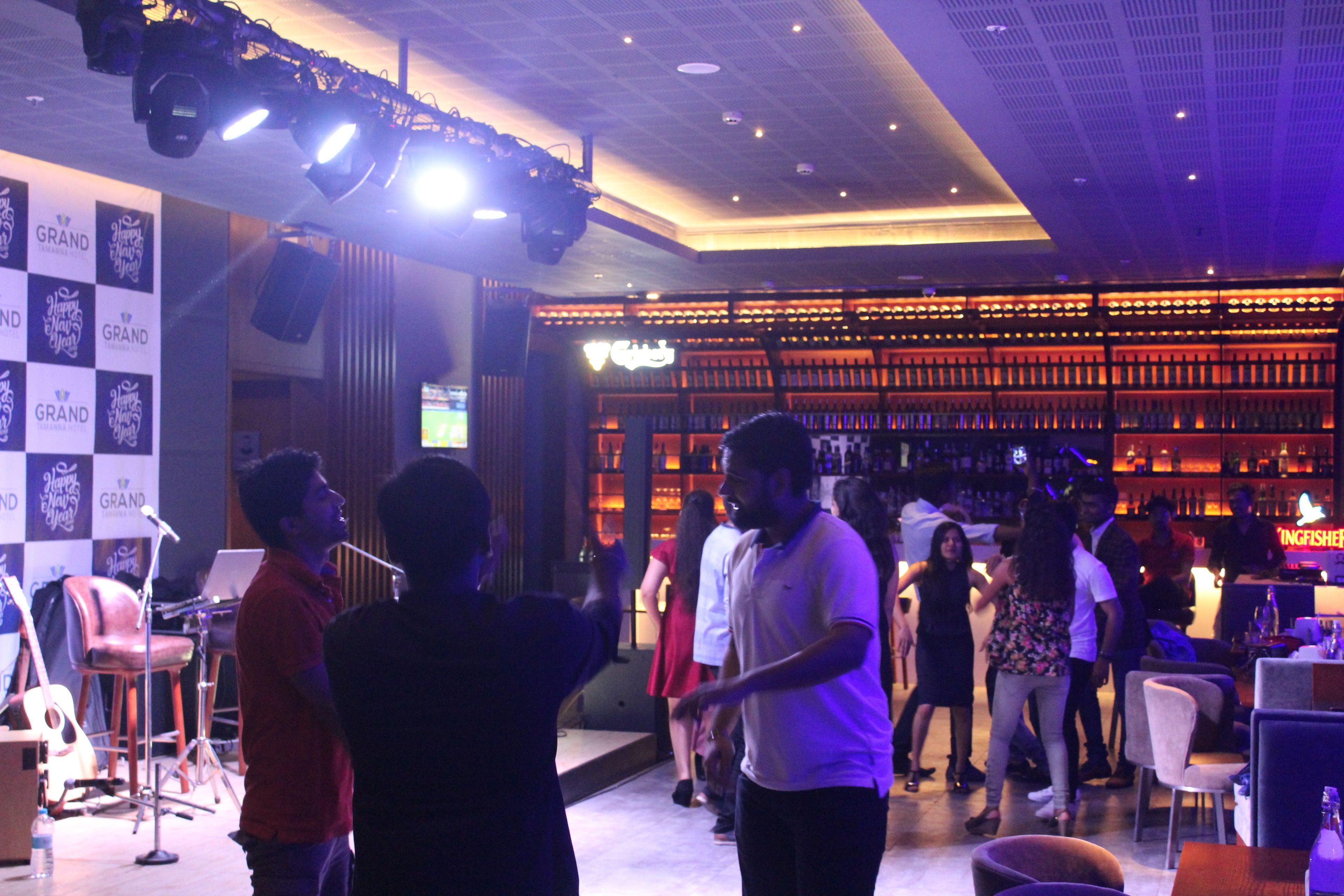 A bar area with a stage, seating, and a bar counter.