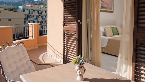 Un balcone con un tavolo, una sedia e una pianta in vaso.