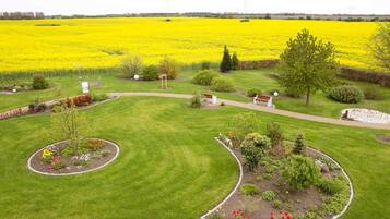 A landscaped garden with a central lawn, surrounded by flower beds and a variety of shrubs.